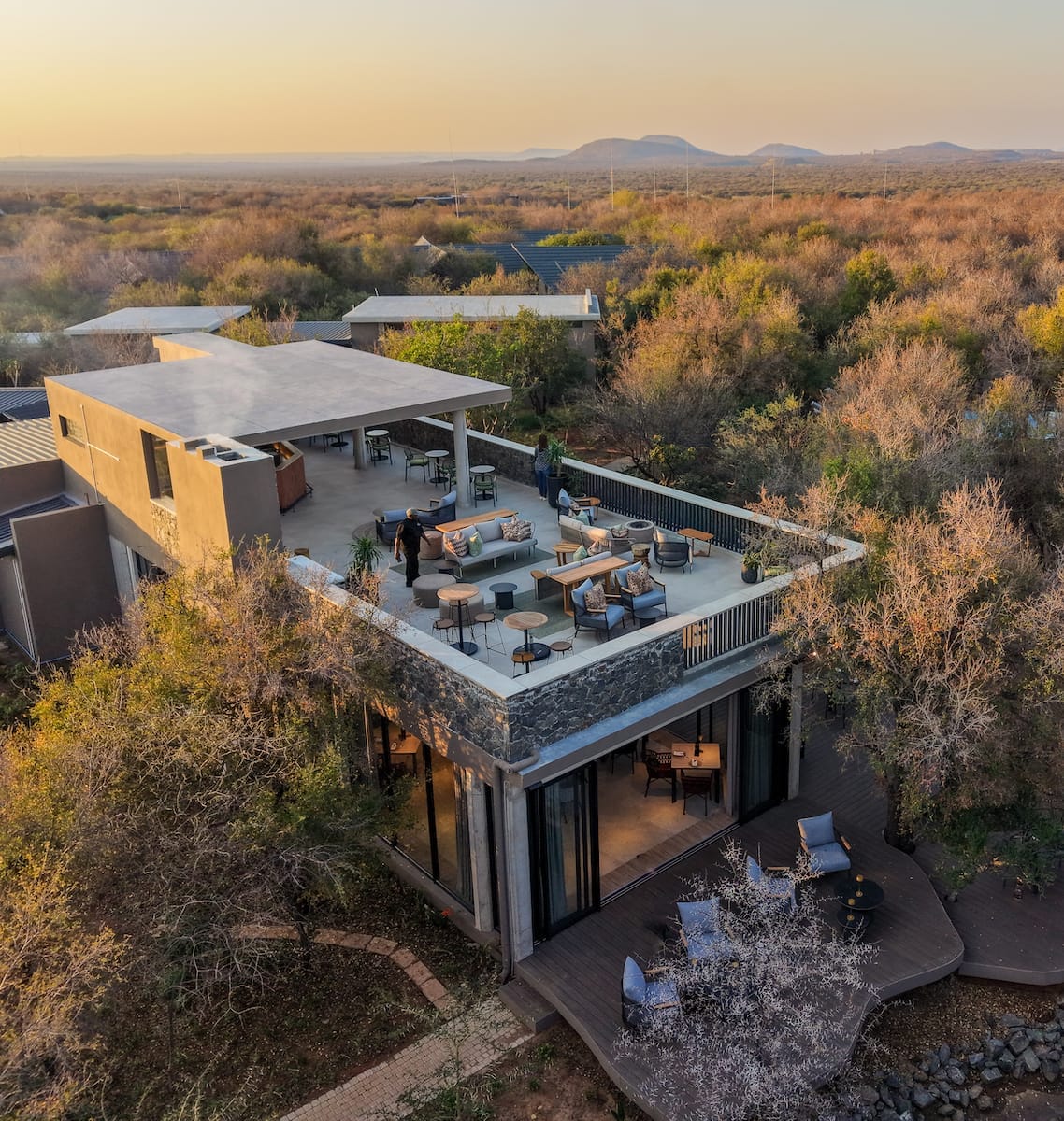 Aerial view of the lodge rooftop terrace and bushveld at sunset